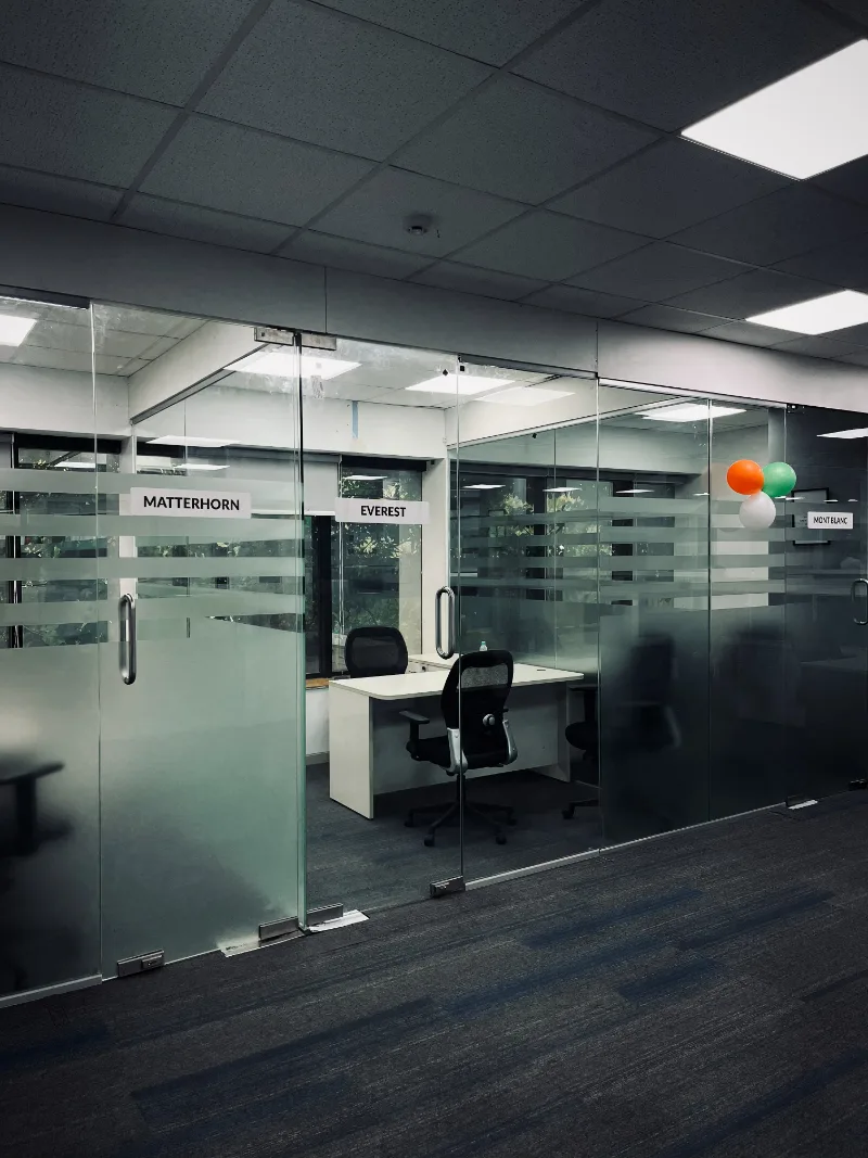 Glass meeting rooms on the office floor, each named after a mountain.