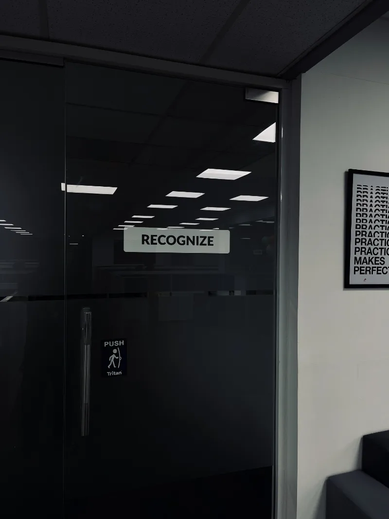 The Recognize sign on the glass door of the office floor.
