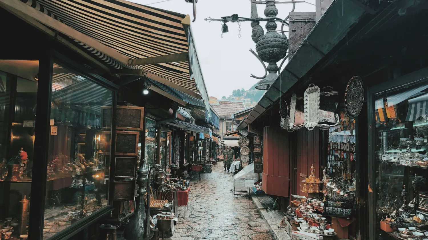 A narrow bazaar street lined with metalwork and craft shops.