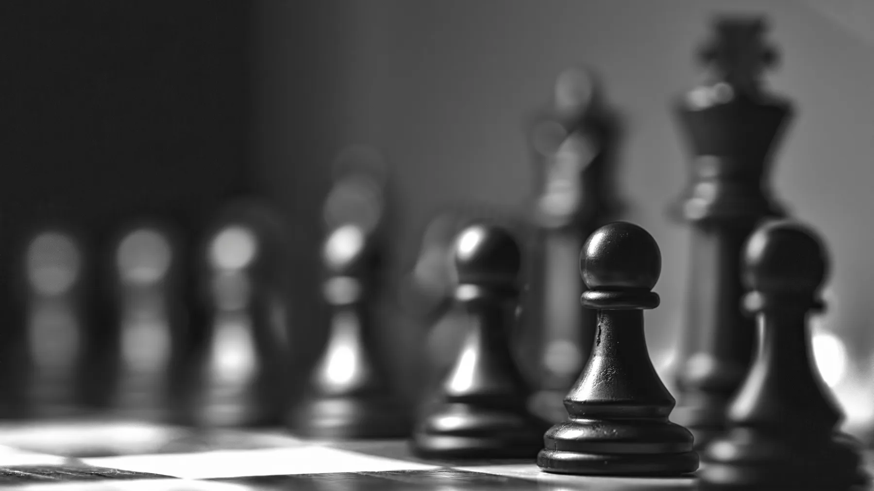 Chess pieces on a board, one pawn sharp in the foreground.