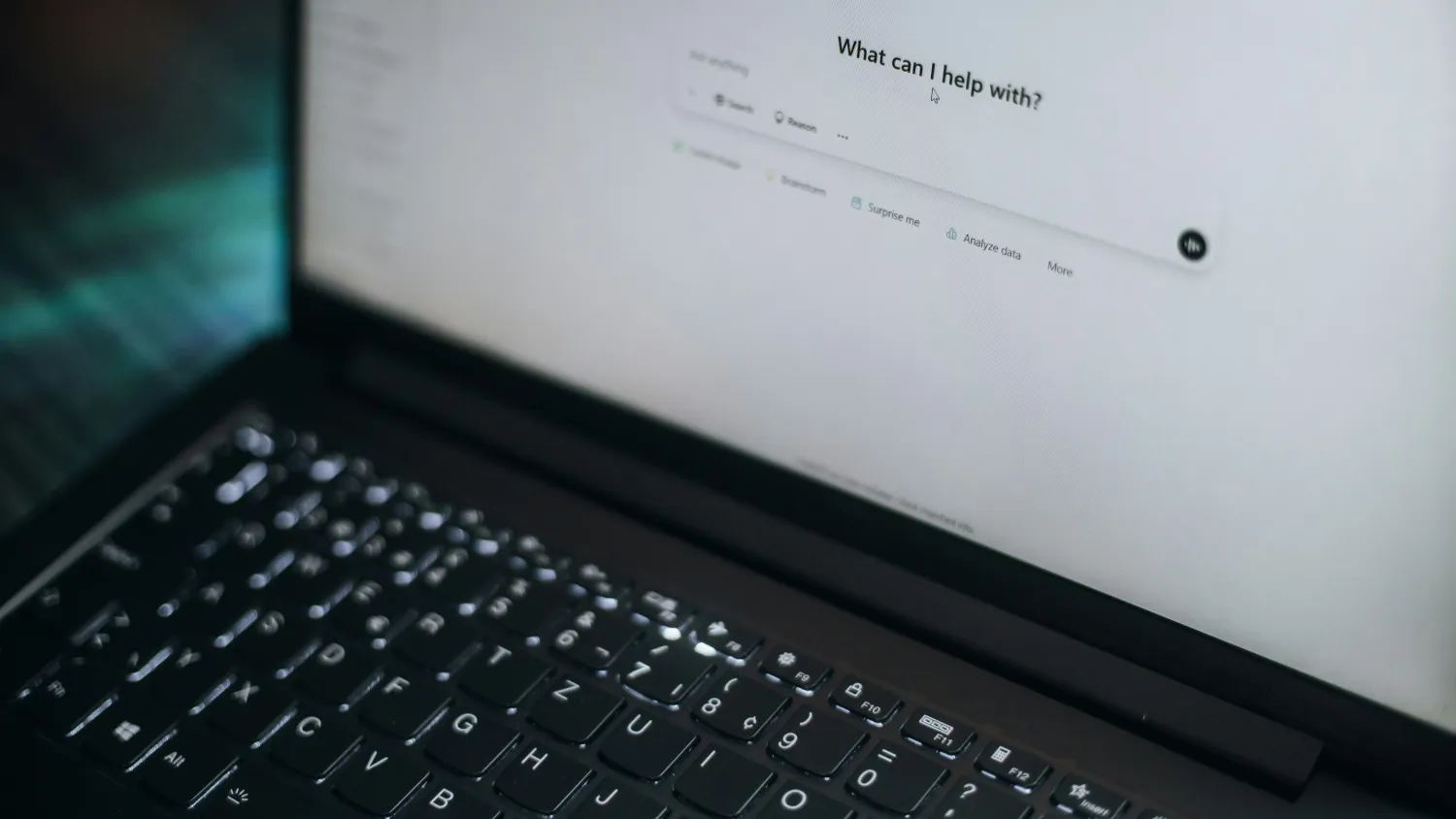 A laptop showing an AI assistant asking what it can help with.