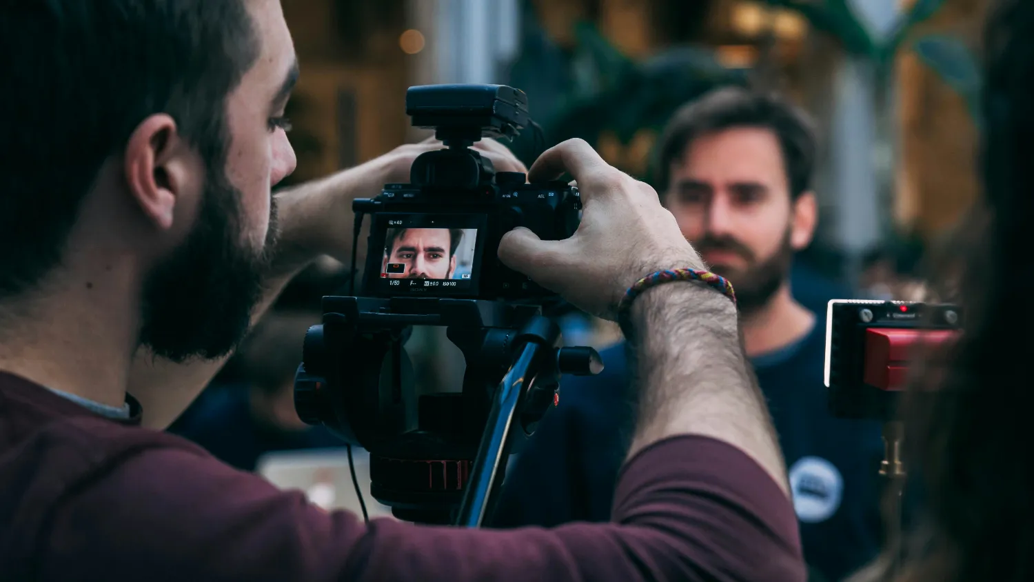 A camera operator filming a man speaking to camera.