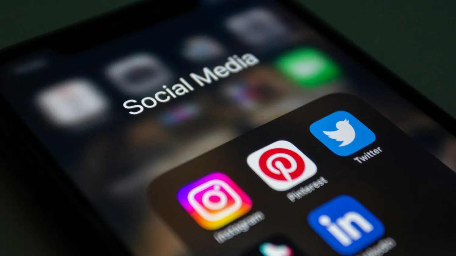 Social app icons lit up on a phone screen under the words Social Media.
